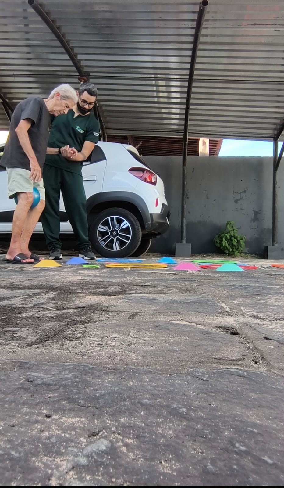 Fisioterapeuta da LarAtivo atendendo paciente idoso em casa com equipamentos